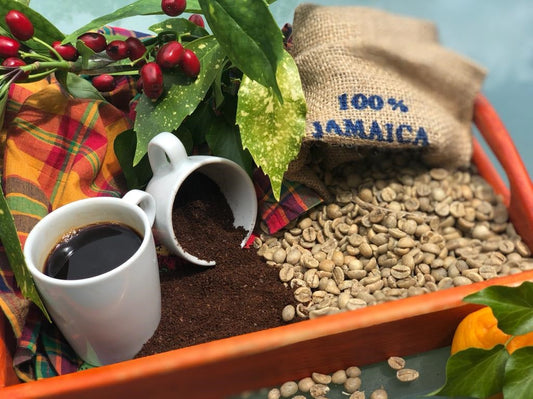Freshly roasted Jamaican Blue Mountain Coffee beans with a steaming cup on wooden table – Tropical Temptations